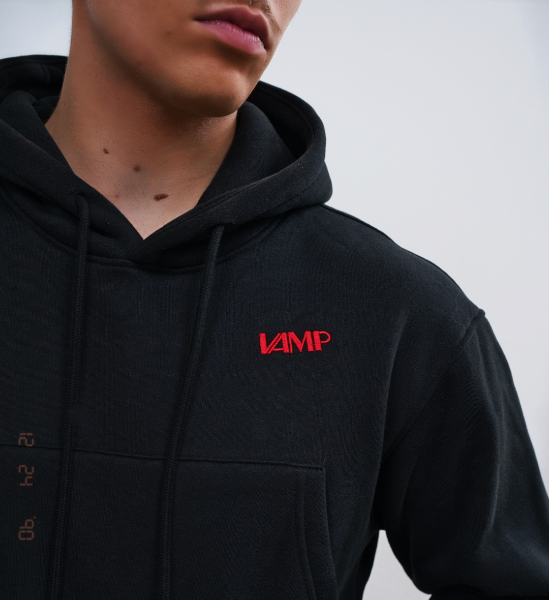 A woman wearing a black crop hoodie with the text 'Drip' on it, featuring a hood and drawstrings.